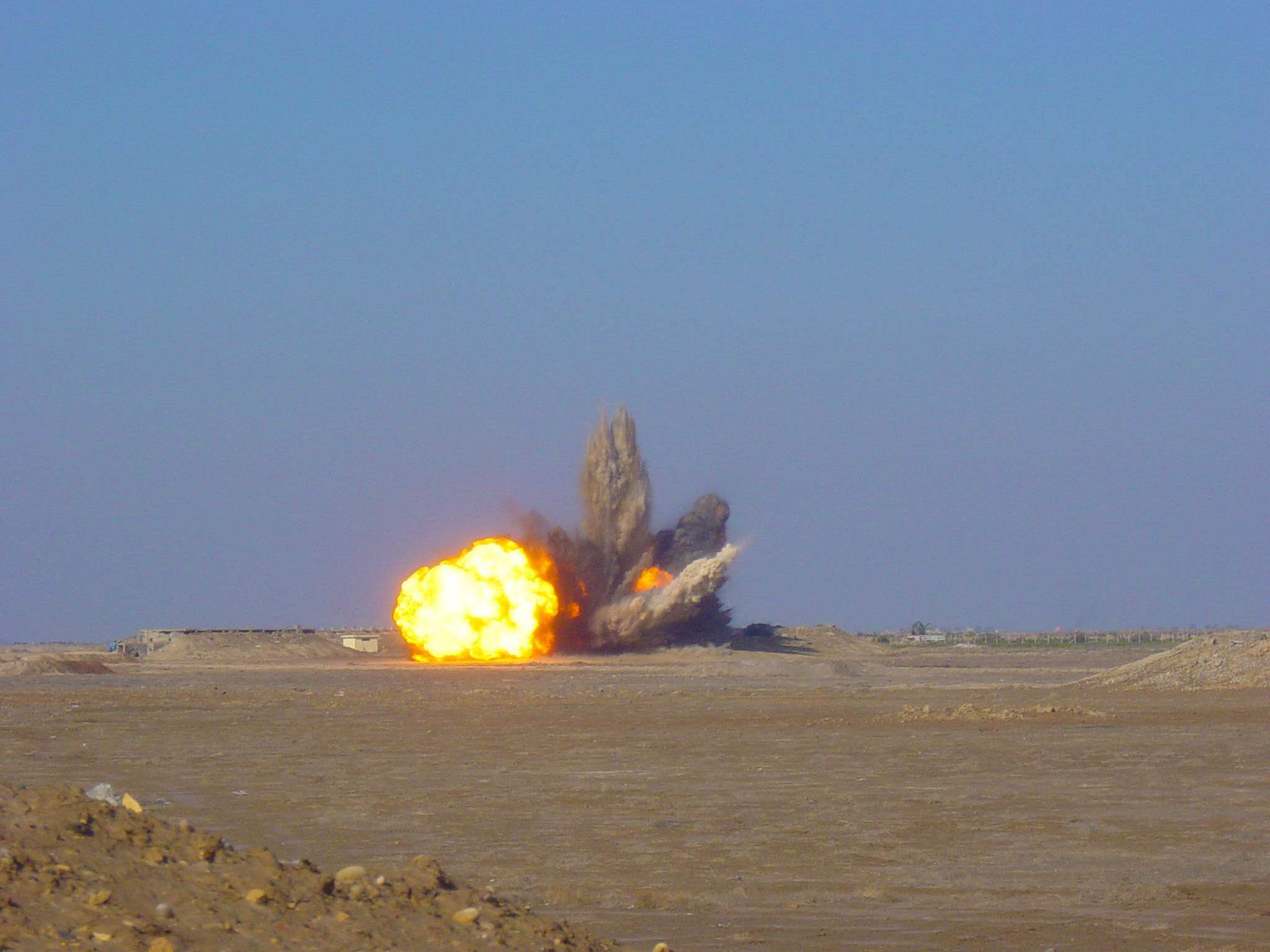 Controlled detonation of a prepared cache of munitions in the desert