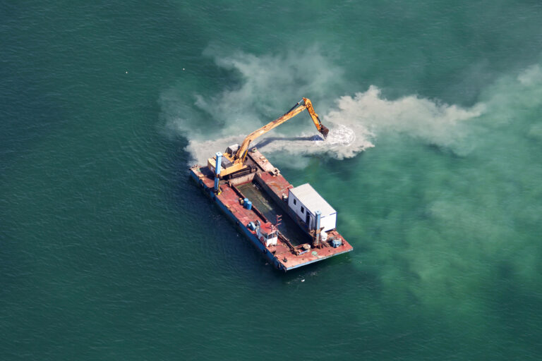Industrial barge with an excavator working in the sea