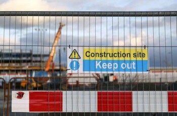 A crane and a construction site being secured behind safety barriers