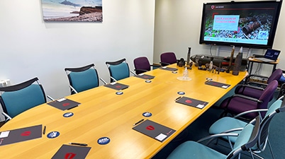 Meeting room setup for UXO Awareness Training by 1st Line Defence, with examples of unexploded ordnance on display