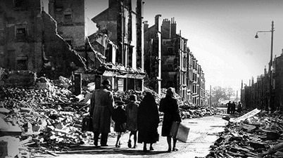Family walking through the devastated streets of Clydebank in Scotland following the Blitz